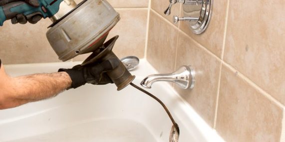 bathtub unclogging plumber unclogs a bathtub